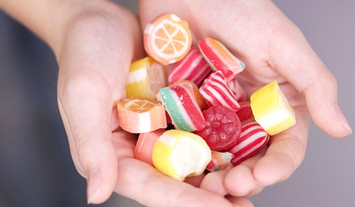 Hand with sweets Gingivitis from sugar