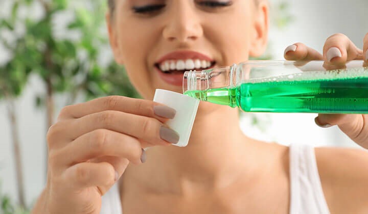 Woman with mouthwash Mouthwash against bad breath
