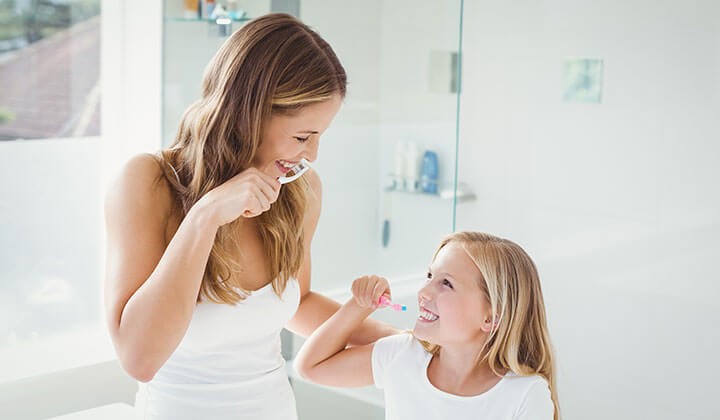 Mother and daughter brushing their teeth Oral hygiene for healthy oral mucosa