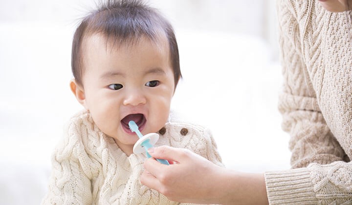 Mother brushes her baby's teeth Baby & Teething: Brushing the first teeth